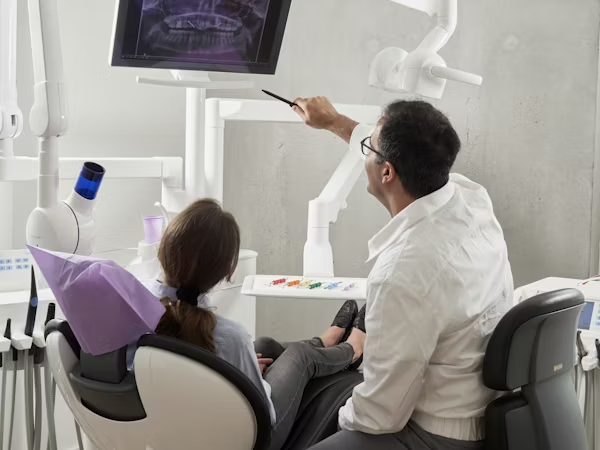 a dentist educating a patient about her dental x-ray result
