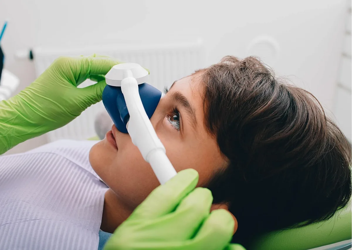 Patient receiving nitrous oxide through a nasal mask as part of sedation dentistry.