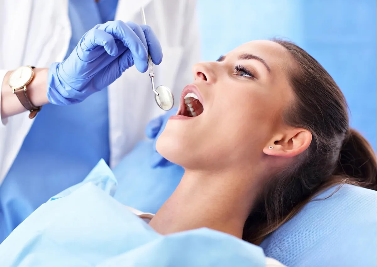 Dentist examining a patient’s tooth during an evaluation for root canal and crown treatment.