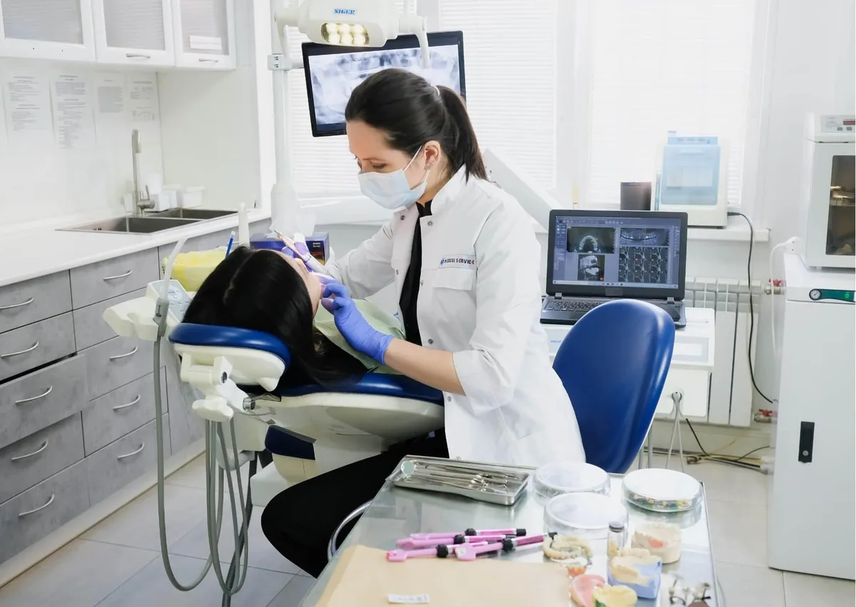 Dentist examining a patient’s teeth for signs of what cavities can look like during a dental exam.