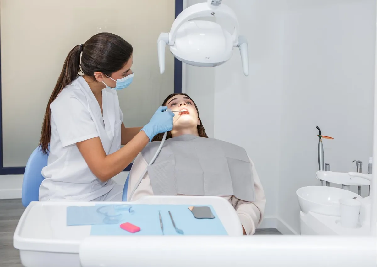 Dental professional examining a patient during a visit related to dry mouth concerns.