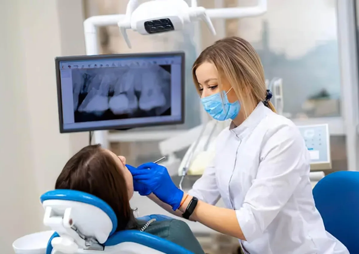 Dentist examining a patient to determine whether affordable dental implants are a suitable tooth replacement option.