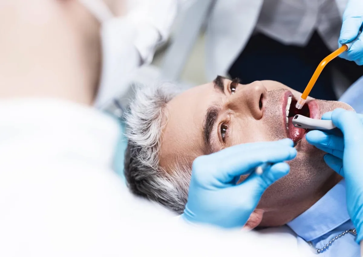 Dentist examining a patient’s tooth to determine whether root canal treatment or extraction is needed.