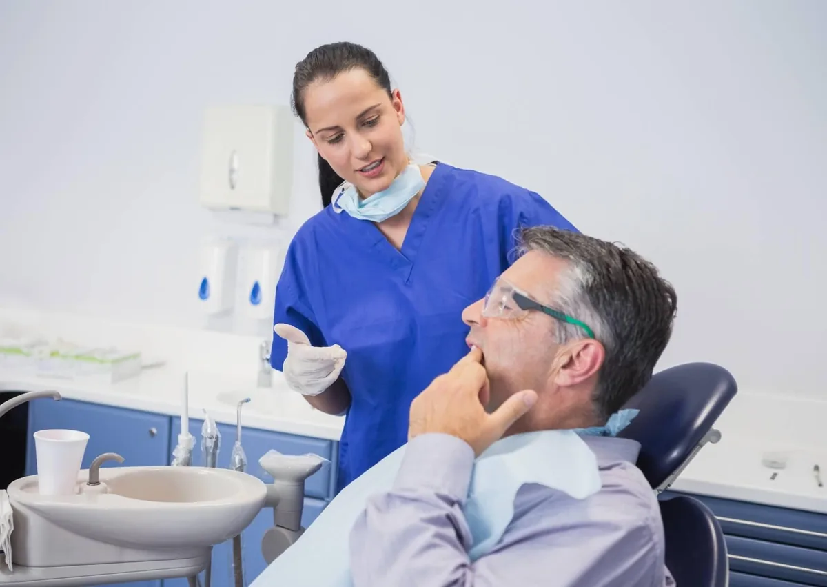 Dentist discussing root canal vs. extraction options with a patient experiencing tooth pain.