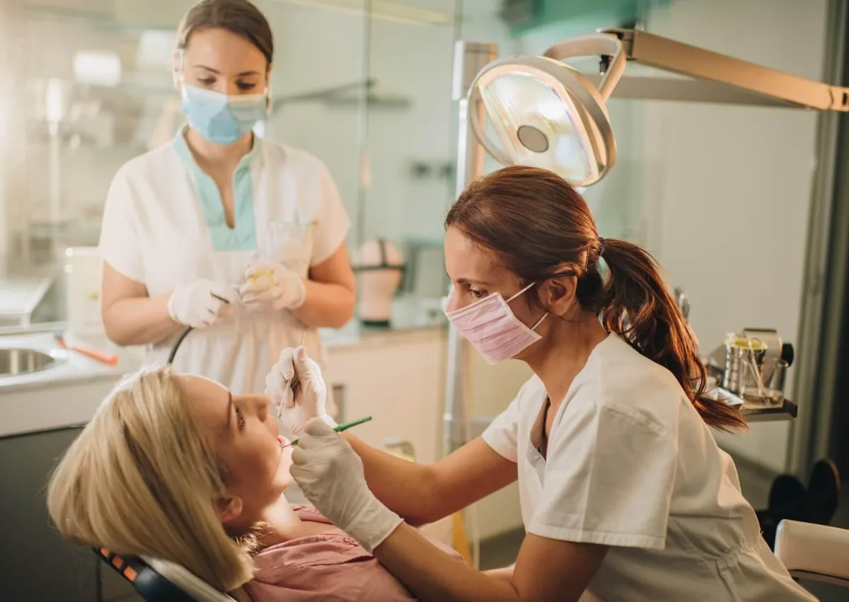 Dentist examining a patient's teeth during a routine dental checkup to detect early signs of tooth decay and help prevent cavities.