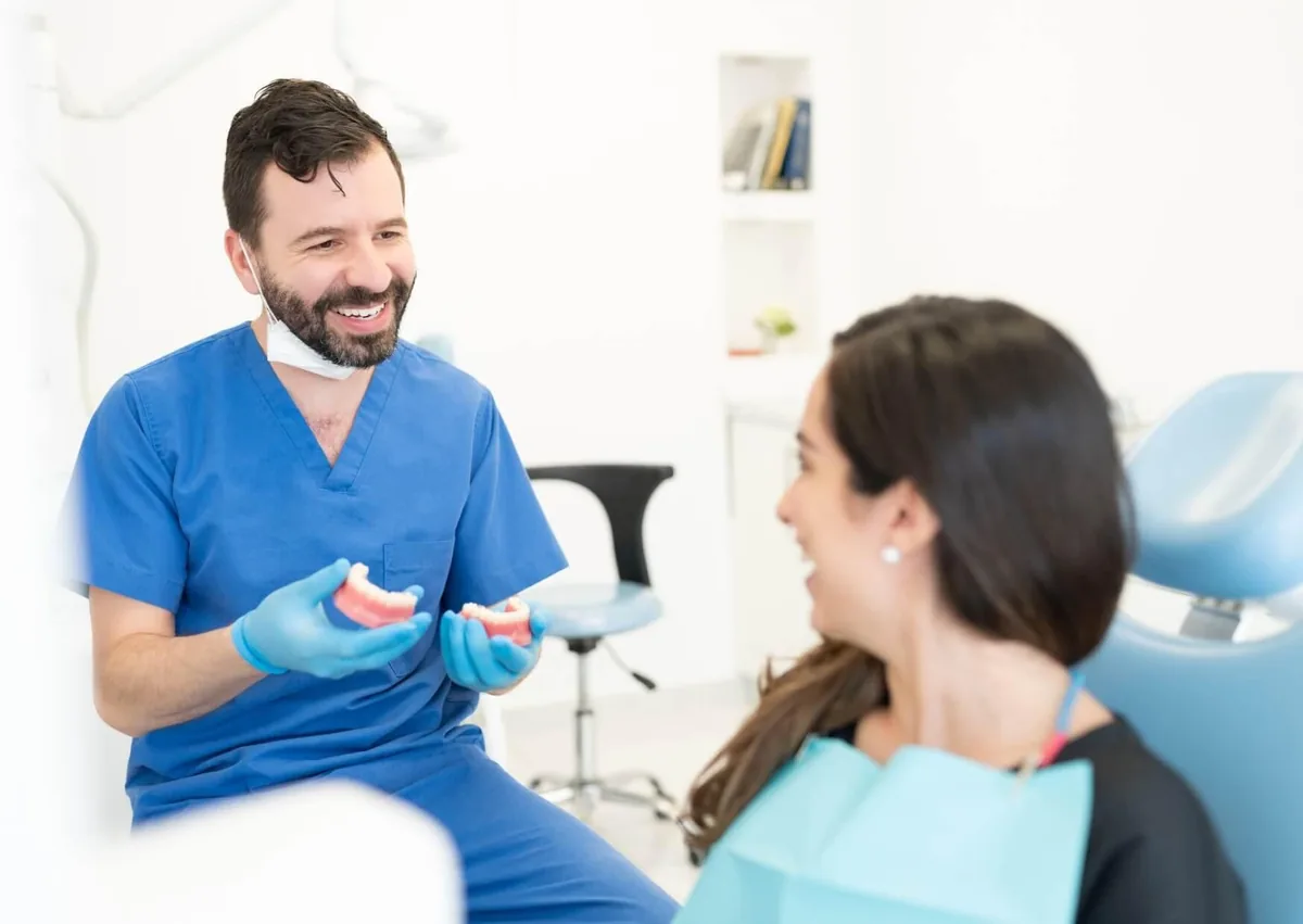 Dentist discussing tooth replacement options with a patient during a consultation about single tooth implant cost.